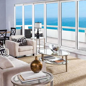 A beautiful living room with sliding glass doors that overlook the ocean.